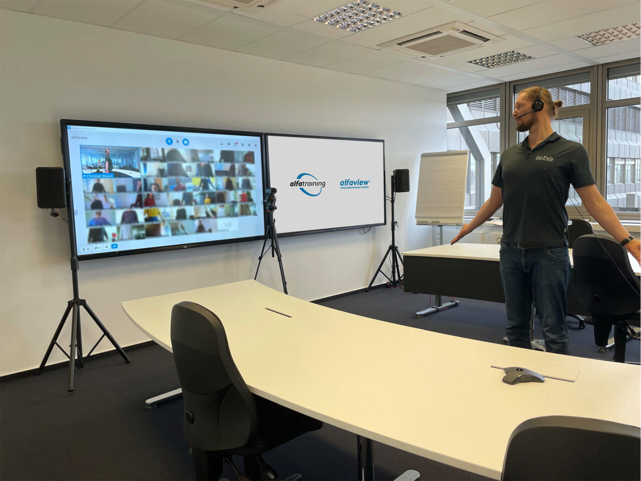 This image shows a health seminar at the alfaview headquarters. The instructor is showing excercices in front of a large screen, the employees repeat the exercices in their home offices.