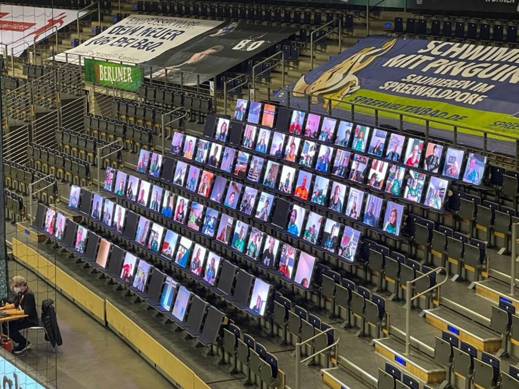 This image shows the alfaview stadium edition. Screens are placed on the seats. Each screen displays one alfaview participant video.