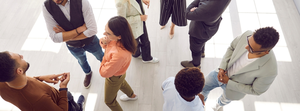 Group of people standing and talking to each other.